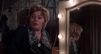 Movie still from “What's the Matter with Helen?” (1971), directed by Curtis Harrington – A woman looking in the mirror in front of a mirror; Close Up shot, Over the shoulder angle