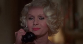 Movie still from “What's the Matter with Helen?” (1971), directed by Curtis Harrington – A woman with blonde curly hair holding a phone; Close Up shot, High angle