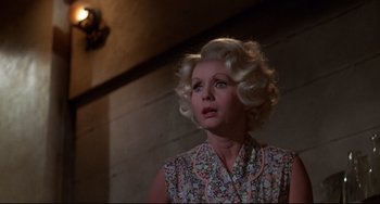 Movie still from “What's the Matter with Helen?” (1971), directed by Curtis Harrington – An older woman in a floral dress looking up; Close Up shot, Low angle