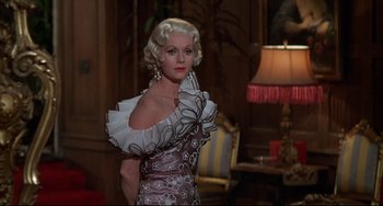 Movie still from “What's the Matter with Helen?” (1971), directed by Curtis Harrington – A woman wearing a dress in a living room setting; Medium shot, Low angle