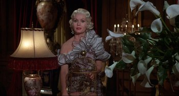Movie still from “What's the Matter with Helen?” (1971), directed by Curtis Harrington – A woman in a dress with a bird cage on her shoulder; Medium shot, Low angle
