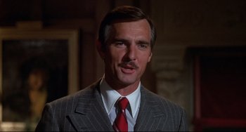 Movie still from “What's the Matter with Helen?” (1971), directed by Curtis Harrington – A person wearing a suit and tie; Close Up shot, Low angle