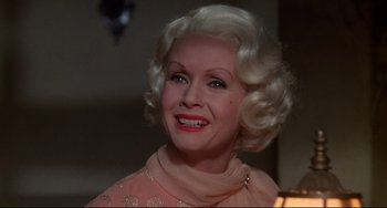 Movie still from “What's the Matter with Helen?” (1971), directed by Curtis Harrington – An older woman with blonde hair wearing a pink dress; Close Up shot, Over the shoulder angle