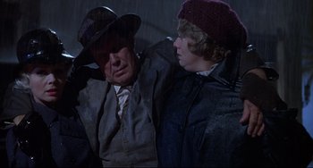 Movie still from “What's the Matter with Helen?” (1971), directed by Curtis Harrington – A man and a young woman sitting next to each other in the rain; Medium shot, Low angle