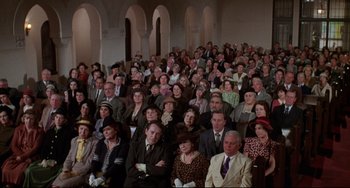 Movie still from “What's the Matter with Helen?” (1971), directed by Curtis Harrington – A large group of people sitting together in a room; Wide shot, High angle
