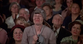 Movie still from “What's the Matter with Helen?” (1971), directed by Curtis Harrington – An older woman with a hat on her head crying in front of an audience; Medium shot, Low angle