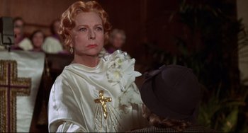 Movie still from “What's the Matter with Helen?” (1971), directed by Curtis Harrington – An older woman in a white dress and a hat; Close Up shot, Over the shoulder angle