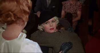 Movie still from “What's the Matter with Helen?” (1971), directed by Curtis Harrington – A woman in a black hat and a black and white coat; Close Up shot, Over the shoulder angle