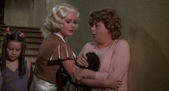 Movie still from “What's the Matter with Helen?” (1971), directed by Curtis Harrington – Two women are holding each other and one of them is holding a mirror; Medium shot, Over the shoulder angle