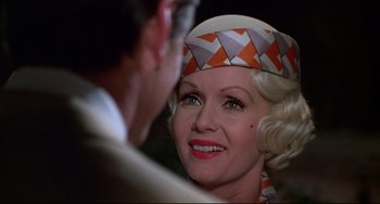 Movie still from “What's the Matter with Helen?” (1971), directed by Curtis Harrington – An older woman wearing an orange and white hat; Close Up shot, Over the shoulder angle
