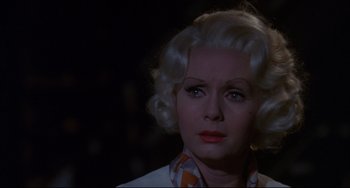 Movie still from “What's the Matter with Helen?” (1971), directed by Curtis Harrington – An older woman with blonde hair wearing a checkered shirt; Close Up shot, Over the shoulder angle