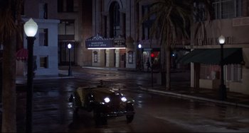 Movie still from “What's the Matter with Helen?” (1971), directed by Curtis Harrington – An old car driving down a street at night; Extreme Wide shot, High angle