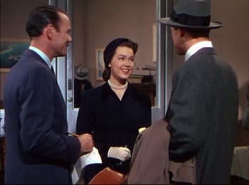 Movie still from “When Worlds Collide” (1951), directed by Rudolph Maté – A group of people standing around each other in a room; Medium shot, Over the shoulder angle