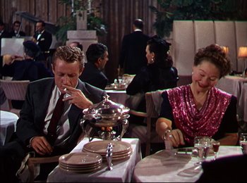 Movie still from “When Worlds Collide” (1951), directed by Rudolph Maté – A man and a woman sitting at a dinner table; Medium shot, Over the shoulder angle