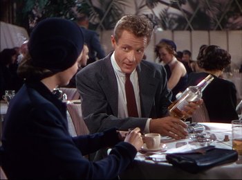 Movie still from “When Worlds Collide” (1951), directed by Rudolph Maté – A man and woman sitting at a table with a bottle of alcohol; Medium shot, Over the shoulder angle