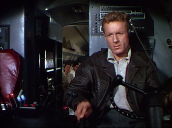 Movie still from “When Worlds Collide” (1951), directed by Rudolph Maté – A man in a leather jacket sitting on a train; Medium shot, Low angle
