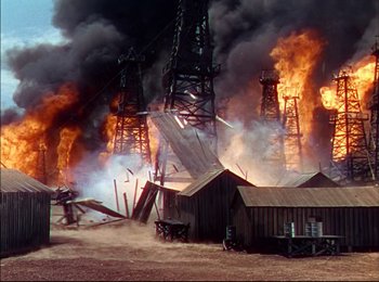 Movie still from “When Worlds Collide” (1951), directed by Rudolph Maté – An oil rig on fire in the middle of a field; Extreme Wide shot, High angle