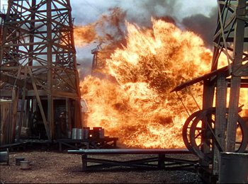 Movie still from “When Worlds Collide” (1951), directed by Rudolph Maté – An oil well is on fire with oil pumps in the background; Extreme Wide shot, Low angle