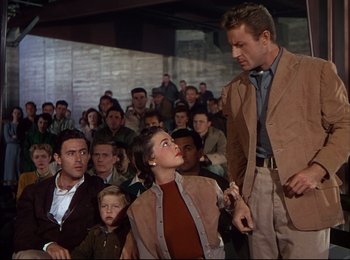 Movie still from “When Worlds Collide” (1951), directed by Rudolph Maté – A group of people sitting in front of a crowd; Medium shot, Low angle