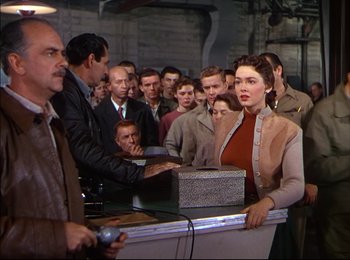 Movie still from “When Worlds Collide” (1951), directed by Rudolph Maté – A group of people standing around a counter; Medium shot, High angle