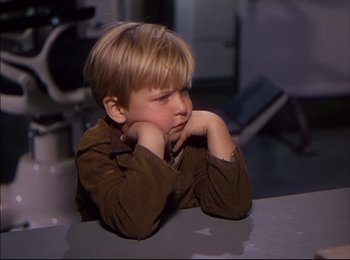 Movie still from “When Worlds Collide” (1951), directed by Rudolph Maté – A little boy sitting at a table with his head resting on his hands; Close Up shot, High angle