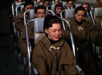 Movie still from “When Worlds Collide” (1951), directed by Rudolph Maté – A group of people sitting in a row of chairs; Medium shot, High angle