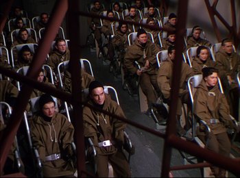 Movie still from “When Worlds Collide” (1951), directed by Rudolph Maté – A group of people sitting in a row of chairs; Wide shot, High angle