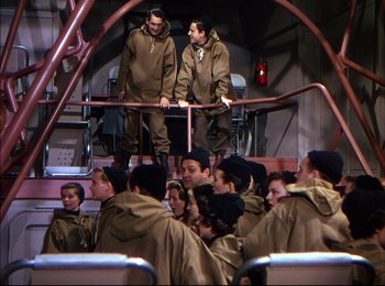 Movie still from “When Worlds Collide” (1951), directed by Rudolph Maté – A group of men in brown jackets standing next to each other; Wide shot, High angle