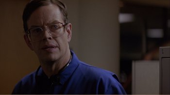 Movie still from “When a Man Falls” (2007), directed by Ryan Eslinger – A person wearing glasses and a blue shirt; Close Up shot, Over the shoulder angle