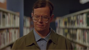Movie still from “When a Man Falls” (2007), directed by Ryan Eslinger – A man with glasses is looking down at his face; Close Up shot, Low angle
