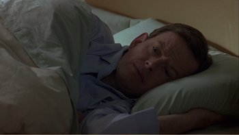 Movie still from “When a Man Falls” (2007), directed by Ryan Eslinger – A person laying in a bed; Close Up shot, High angle