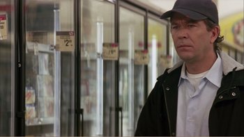 Movie still from “When a Man Falls” (2007), directed by Ryan Eslinger – A man standing in front of a freezer in a grocery store; Close Up shot, Over the shoulder angle