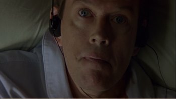 Movie still from “When a Man Falls” (2007), directed by Ryan Eslinger – A person wearing headphones; Close Up shot, Overhead angle