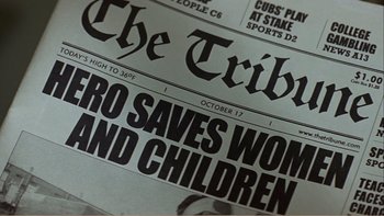 Movie still from “When a Man Falls” (2007), directed by Ryan Eslinger – Image of a newspaper with the headline " hero saves women and children "; Extreme Close Up shot, High angle