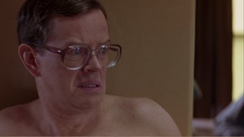 Movie still from “When a Man Falls” (2007), directed by Ryan Eslinger – An older man with glasses is sitting in a room; Close Up shot, Low angle