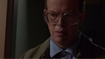 Movie still from “When a Man Falls” (2007), directed by Ryan Eslinger – A person wearing glasses and a jacket; Close Up shot, Low angle