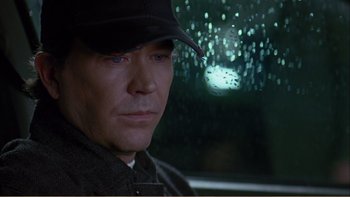 Movie still from “When a Man Falls” (2007), directed by Ryan Eslinger – A person wearing a hat in the rain; Close Up shot, Low angle