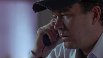 Movie still from “When a Man Falls” (2007), directed by Ryan Eslinger – A person talking on a cell phone; Close Up shot, Low angle