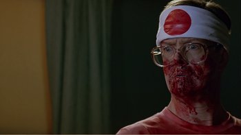 Movie still from “When a Man Falls” (2007), directed by Ryan Eslinger – A man with blood all over his face and head; Close Up shot, Over the shoulder angle