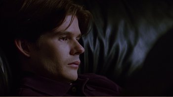Movie still from “When a Man Falls” (2007), directed by Ryan Eslinger – A person sitting on a couch; Close Up shot, High angle