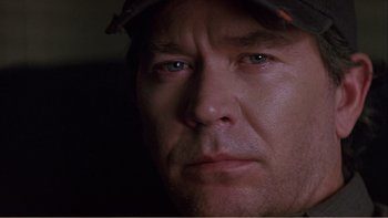 Movie still from “When a Man Falls” (2007), directed by Ryan Eslinger – A person wearing a hat; Close Up shot, Over the shoulder angle