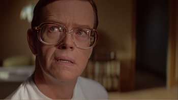 Movie still from “When a Man Falls” (2007), directed by Ryan Eslinger – An older man wearing glasses and a t - shirt; Close Up shot, Low angle