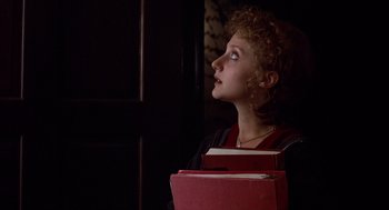 Movie still from “When a Stranger Calls” (1979), directed by Fred Walton – A woman holding a stack of books in her hands; Close Up shot, Low angle