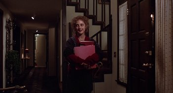 Movie still from “When a Stranger Calls” (1979), directed by Fred Walton – A woman holding a pink box in her hands; Medium shot, Low angle