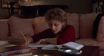 Movie still from “When a Stranger Calls” (1979), directed by Fred Walton – A woman sitting at a table writing on a book; Medium shot, High angle