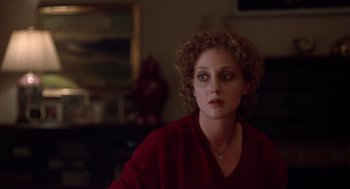 Movie still from “When a Stranger Calls” (1979), directed by Fred Walton – A woman in a red shirt is sitting in a living room; Close Up shot, Over the shoulder angle