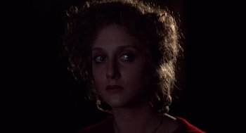 Movie still from “When a Stranger Calls” (1979), directed by Fred Walton – A young woman with curly brown hair is looking at the camera; Close Up shot, Over the shoulder angle