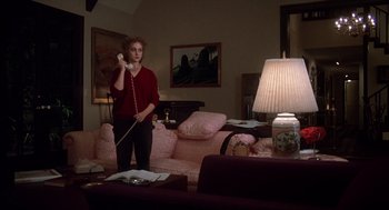 Movie still from “When a Stranger Calls” (1979), directed by Fred Walton – A woman holding a phone up to her ear in a living room; Wide shot, High angle