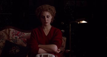 Movie still from “When a Stranger Calls” (1979), directed by Fred Walton – A woman sitting in a chair with her arms crossed; Medium shot, High angle