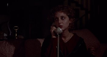 Movie still from “When a Stranger Calls” (1979), directed by Fred Walton – A woman sitting on a couch talking on a phone; Close Up shot, High angle